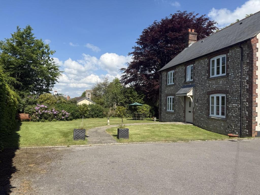 a brick house with a garden and a driveway at South Glebe in Hawkchurch