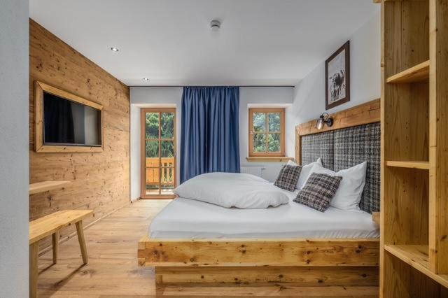 Un dormitorio con una cama grande y un televisor. en Ascherhof, en Landl