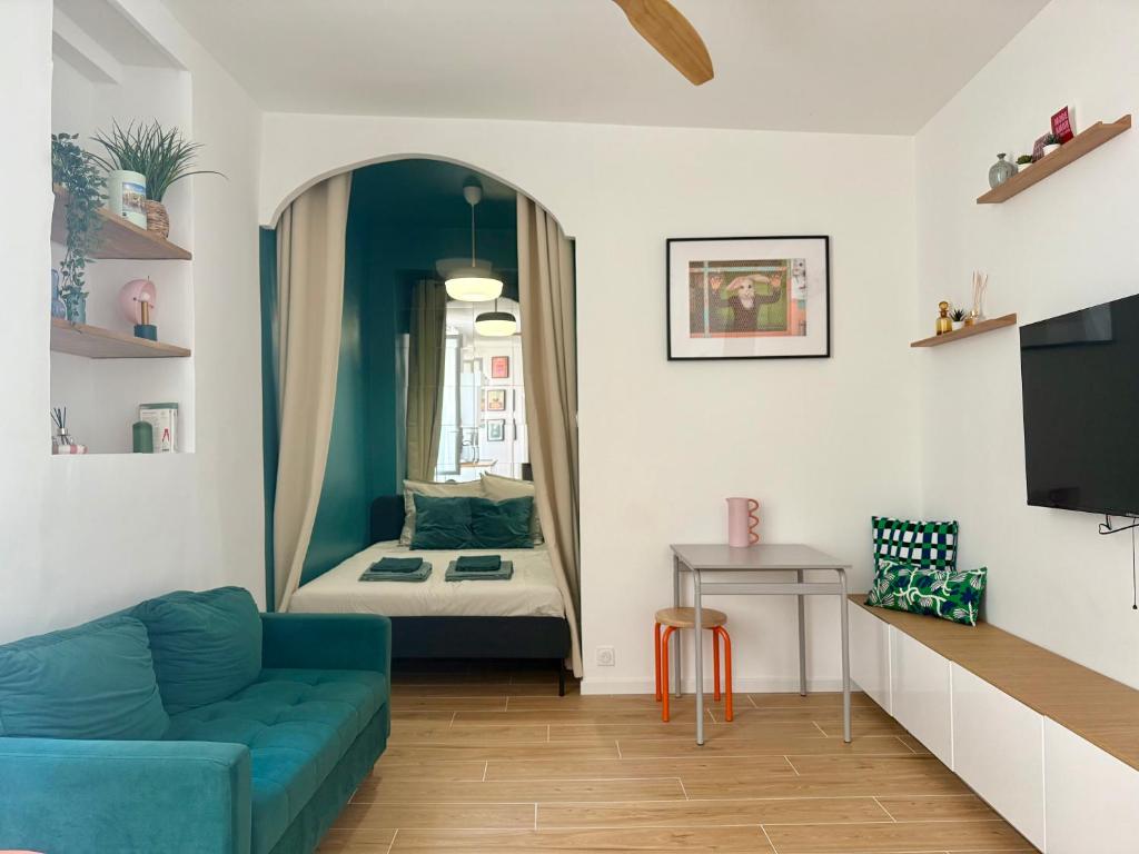 a living room with a blue couch and a bed at Mourillon proche plages in Toulon