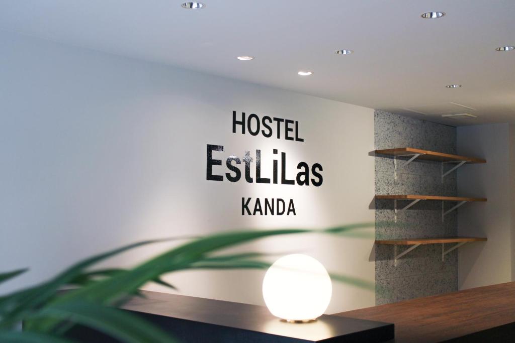 a room with a sign that reads hosteles kaho at ホステルエリーラ神田 HOSTEL EstLiLas KANDA in Tokyo