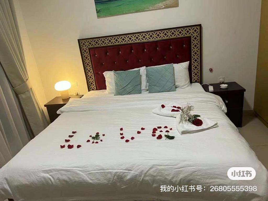 a bed with a bunch of red roses on it at 同鑫青旅 in Ajman 