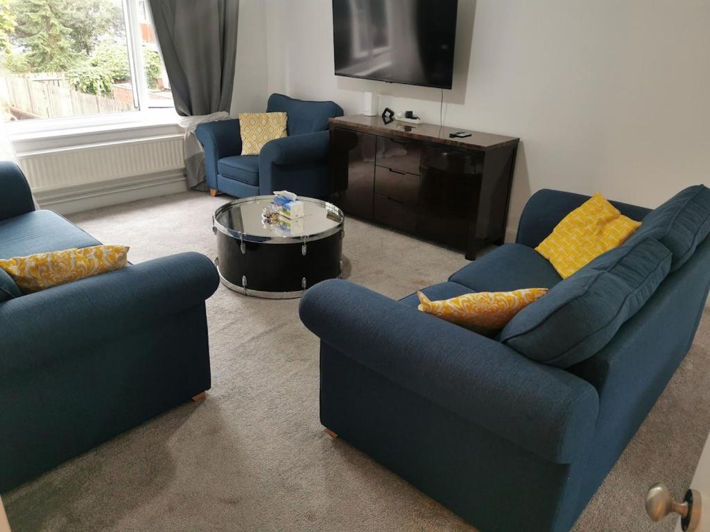 a living room with two blue couches and a table at Newly amazing refurbished two bedroom apartment in Harrow on the Hill