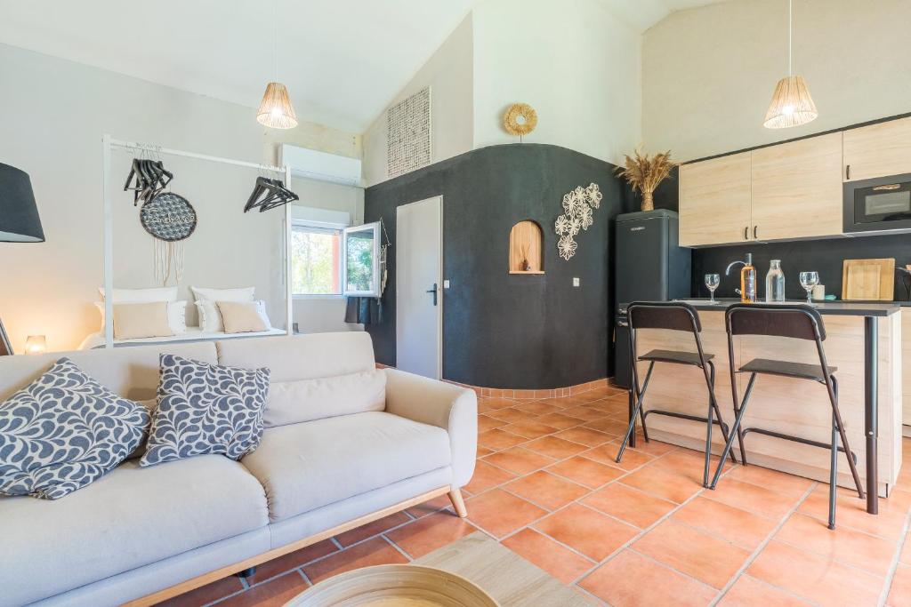 Una sala de estar con un sofá y una cocina. en Domaine Plan Des Devens Tendresse, en Les Roussens