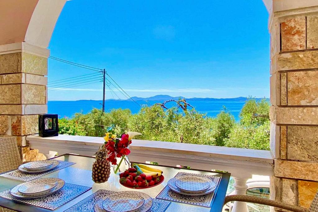 a table with a bowl of fruit on a balcony at NISSAKI SUNLIGHT by Sealand Villas in Nisakion