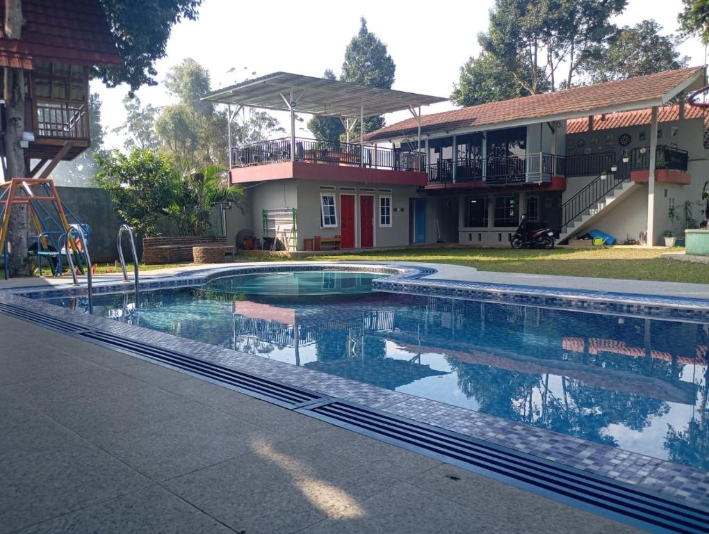 a swimming pool in front of a house at villa omah citeko in Tagalbato