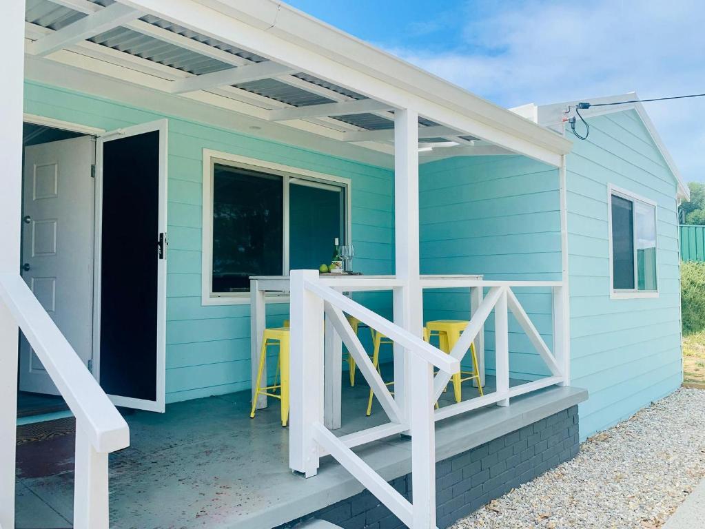 a blue house with a porch with a table and chairs at Playgrounds in Lancelin