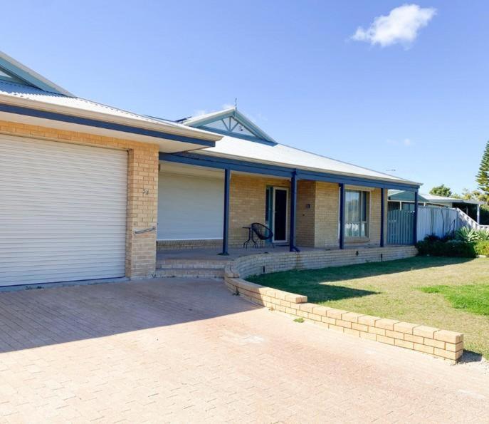 a brick house with a garage and a driveway at White Sands in Lancelin