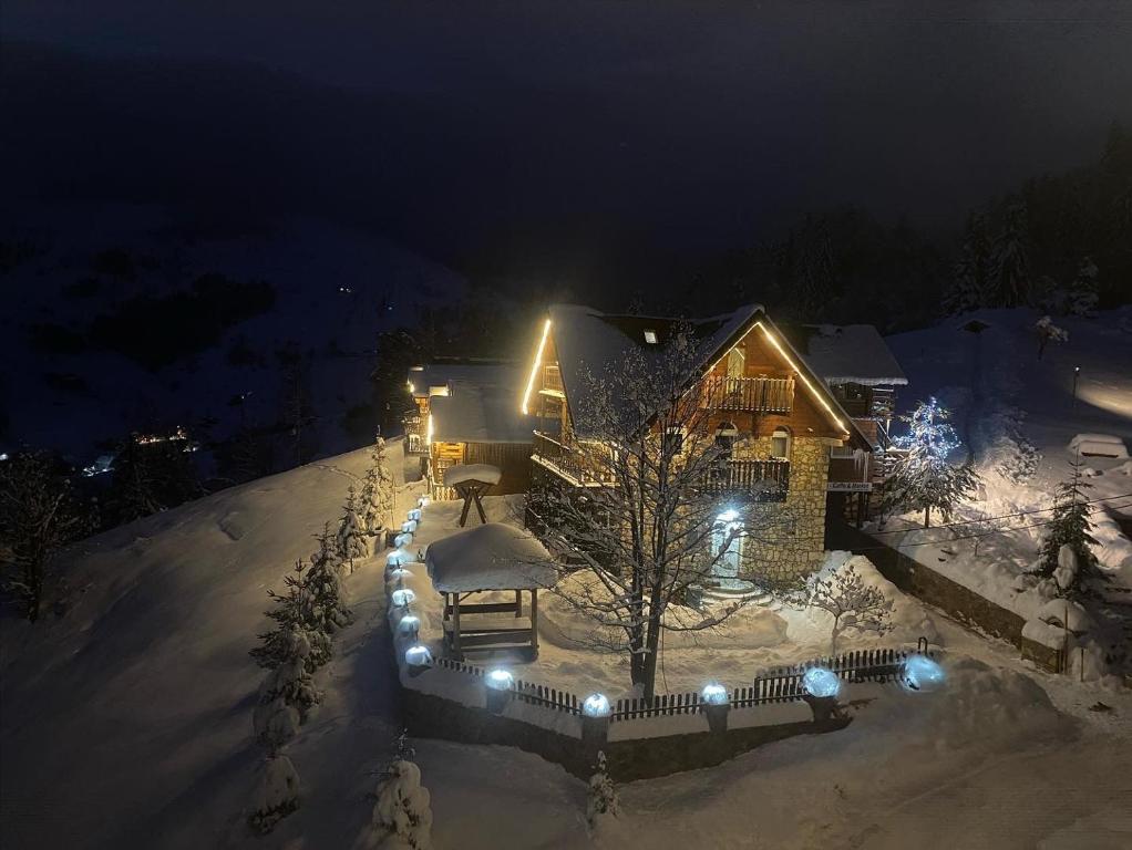 a house covered in snow at night with lights at Shpella e Madhe - Villa e Gurit in Boge