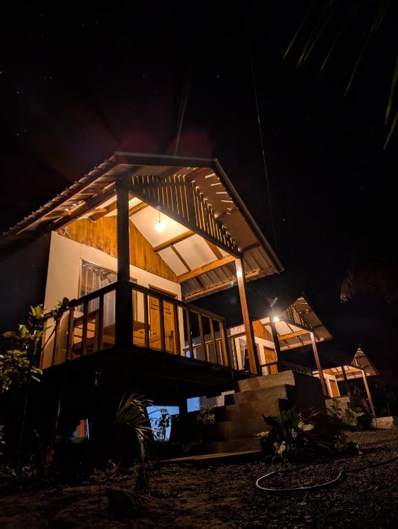 a house at night with a surfboard in front of it at Haris Homestay & Cottages in Senaru