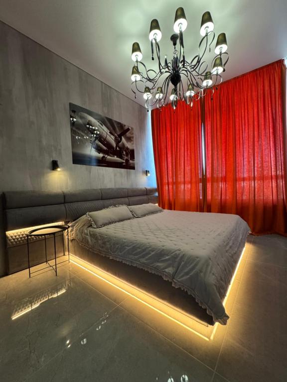 敖德萨ЖК Атмосфера первая линия моря место паркинг的一间卧室配有床和红色窗帘