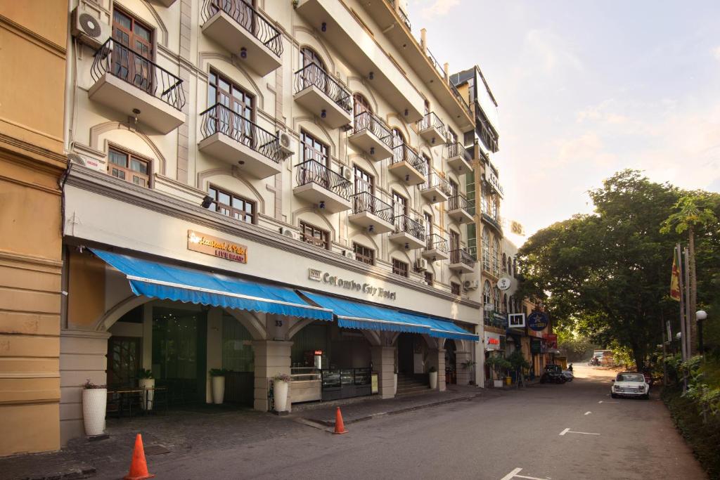 a building with a blue awning on a street at Oak Ray Colombo City Hotel in Colombo