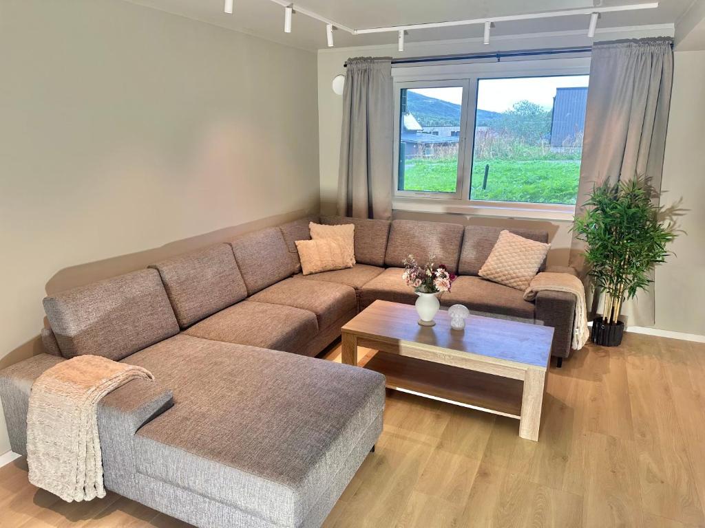 a living room with a couch and a table at Kaldfjord Aurora Aparments New in Tromsø