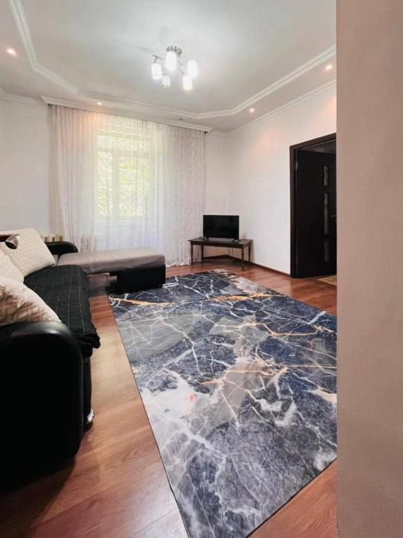 a living room with a large rug on the floor at Международный Аэропорт Алматы Апартаменты "100 метров" in Almaty