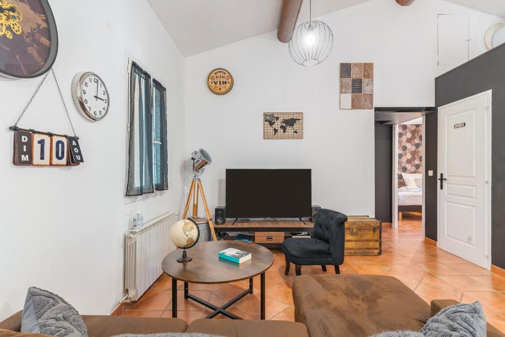 ein Wohnzimmer mit Sofa und Fernseher in der Unterkunft Domaine Plan Des Devens Bien-être in Roussillon