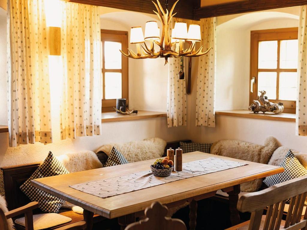 ヴェークシャイトにあるDas Max & Fritzのテーブルと椅子とシャンデリアのあるダイニングルーム