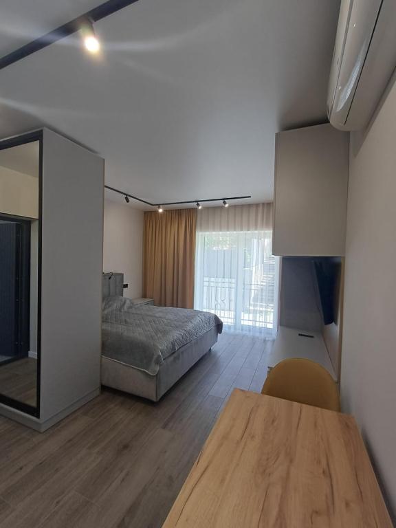ein Schlafzimmer mit einem Bett, einem Tisch und einem Spiegel in der Unterkunft Premium Apartments A&S in Czernowitz