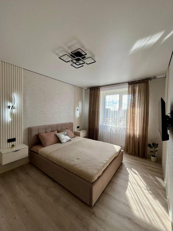 a bedroom with a large bed and a window at Яровиця 9 новобуд in Lutsk