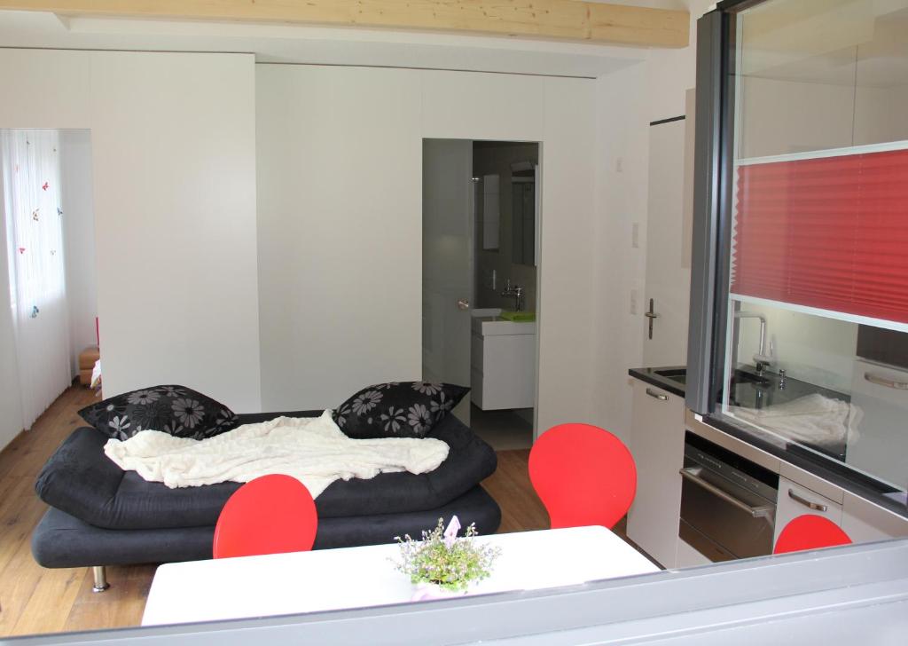 ein Wohnzimmer mit einem Sofa und roten Stühlen in der Unterkunft Haus Steiner in Göschenen
