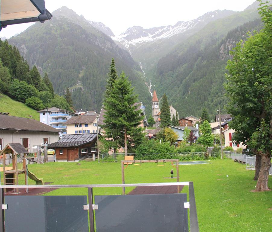 a view of a town with a field and mountains at Haus Steiner in Göschenen