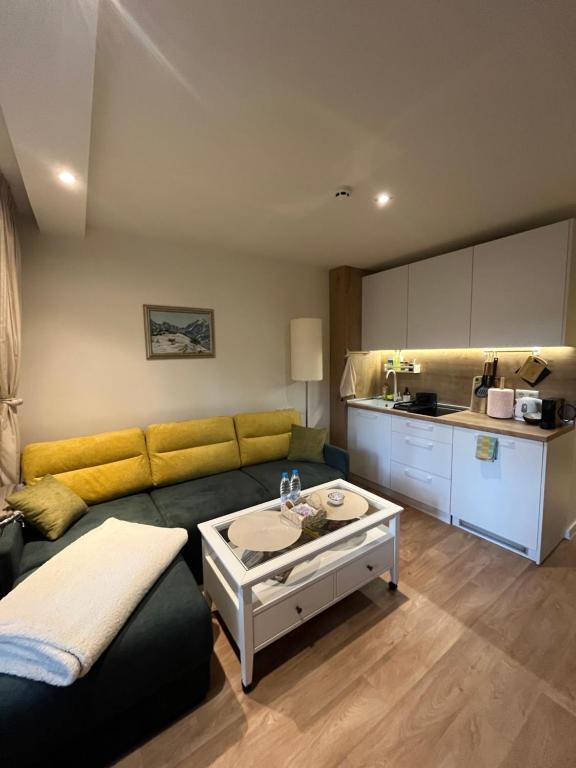 a living room with a couch and a table at Chamkoria Forest View & Spa Apartment in Borovets