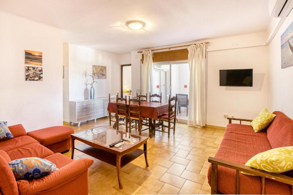 ein Wohnzimmer mit Sofa und Tisch in der Unterkunft Apart en Paseo Marítimo 2-3 in Llança