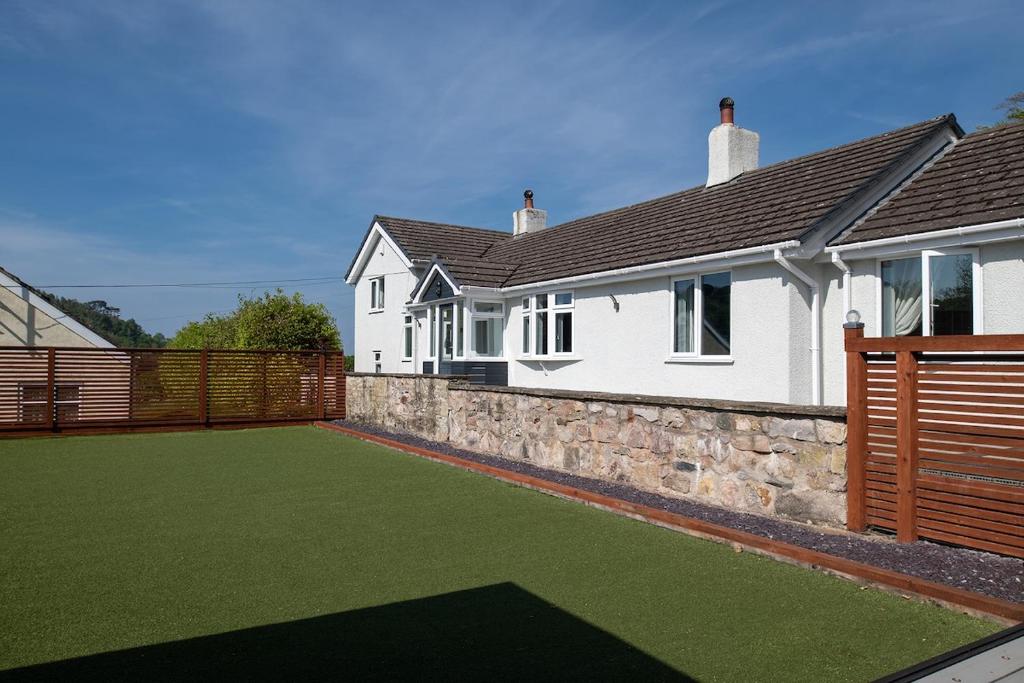 dom ze sztucznym trawnikiem przed nim w obiekcie Pen y coed with hot tub and sauna surrounded by countryside views w mieście Abergele