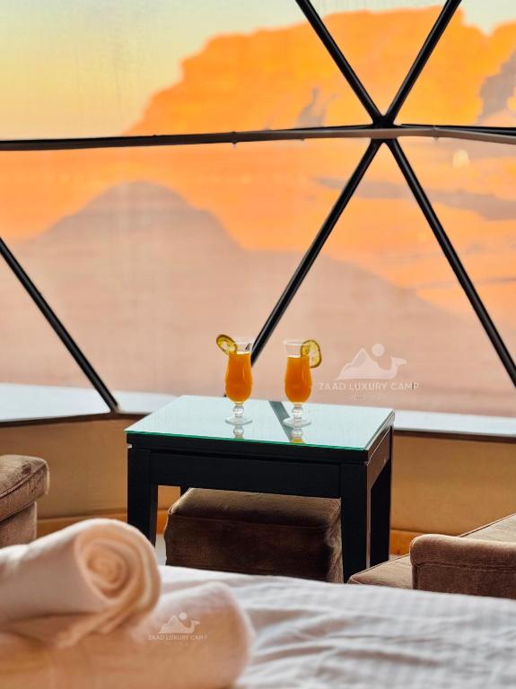 a table with two orange vases on top of it at Wadi Rum ZAAD luxury Camp in Wadi Rum