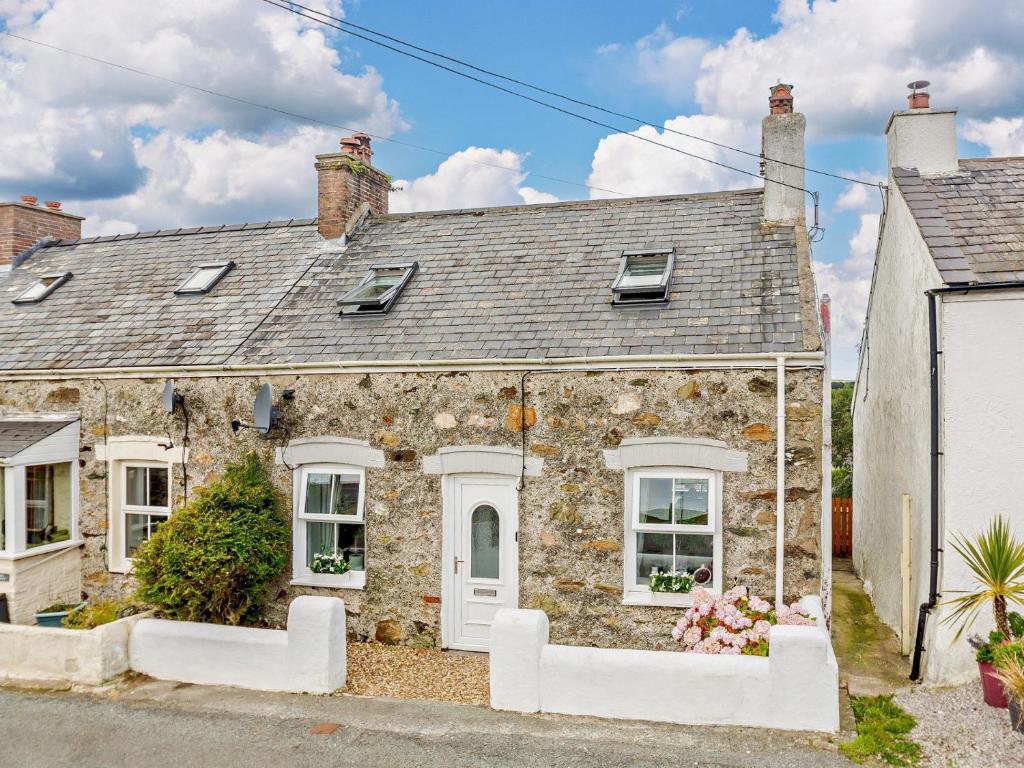 an old stone house with white windows and a roof at 3 Bed in Cemaes 92812 in Llanfechell