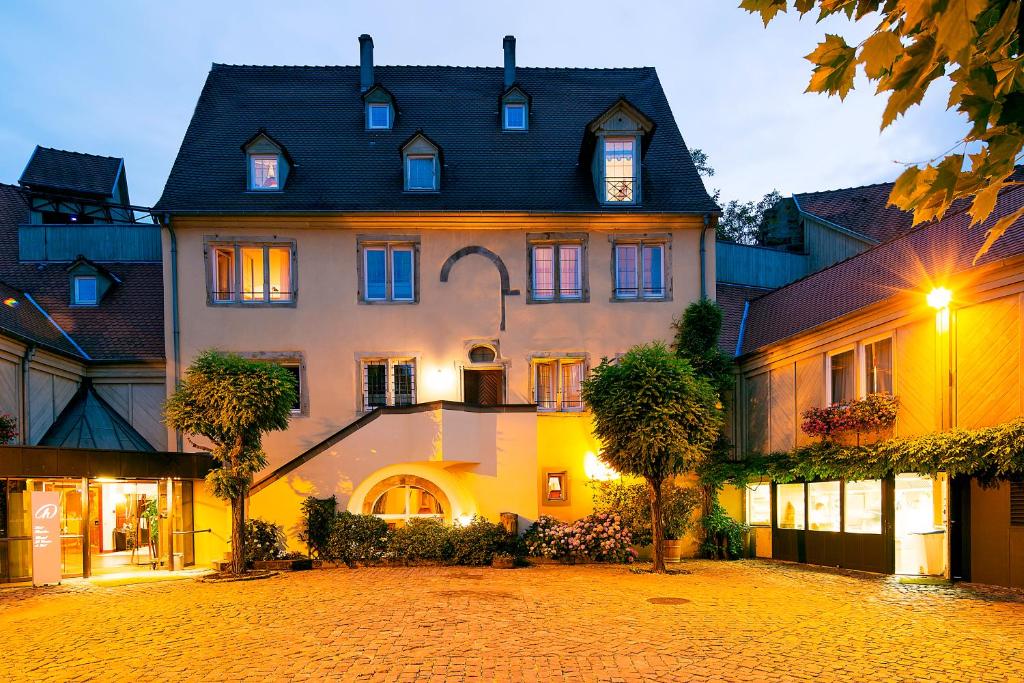 a large white building with a black roof at Hotel &amp; Spa A la cour d&#39;Alsace by HappyCulture in Obernai