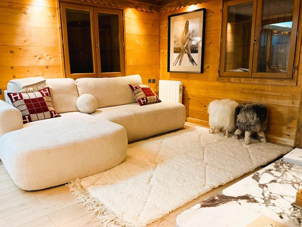 Megève centre في ميجيف: غرفة معيشة مع أريكة وكلابين