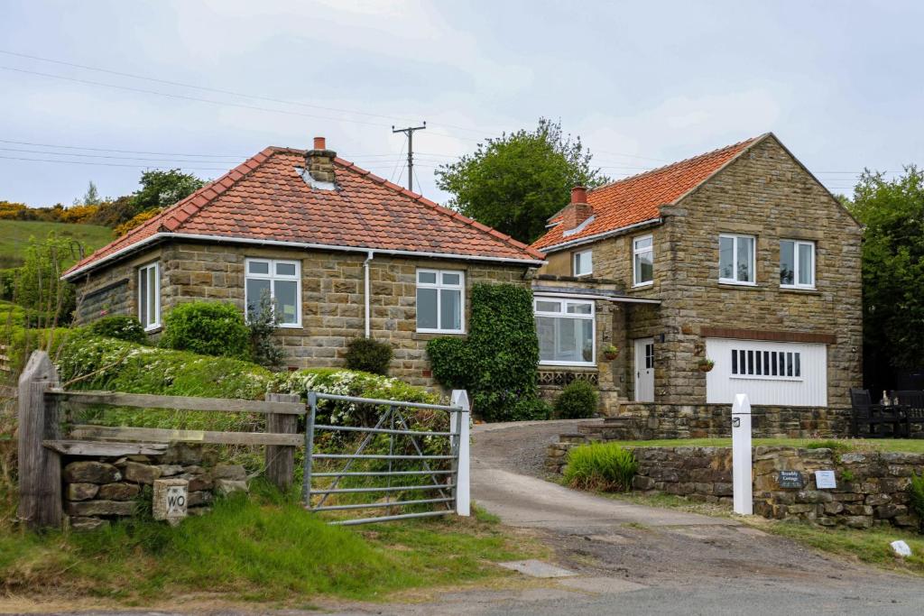 een stenen huis met een hek ervoor bij Brambly Cottage in Whitby