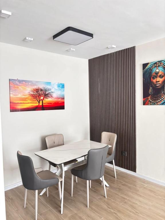 a dining room with a table and chairs and a painting at Stay with queen in Marimbeti