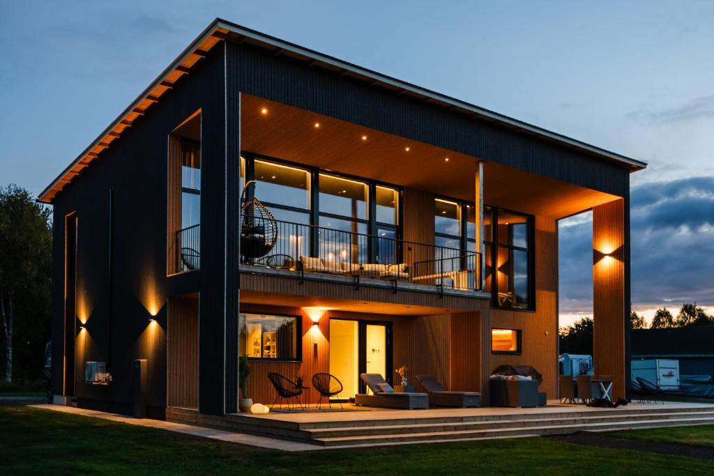 een huis met grote ramen en een balkon bij NEW luxury villa by the river in Rovaniemi