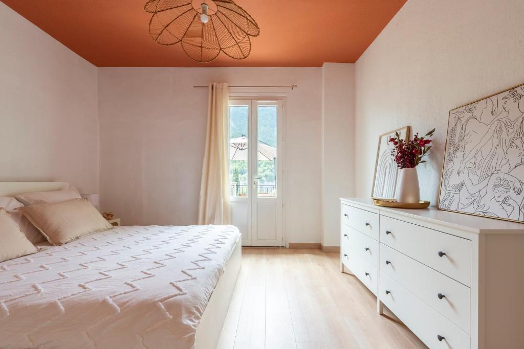 Un dormitorio con una cama y una cómoda y una ventana. en L'Olivier, en Touët-sur-Var
