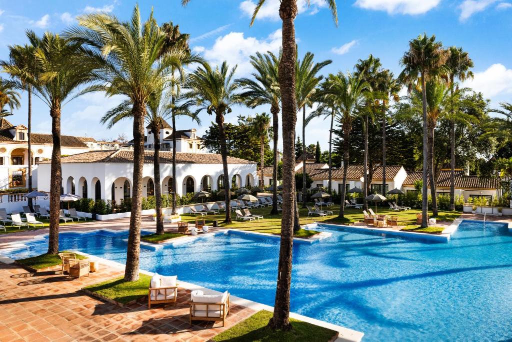 a resort with palm trees and a swimming pool at Hotel Inmood San Roque in Sotogrande