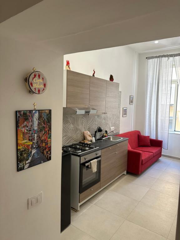 a kitchen with a stove and a red couch at Casetta la Bruna in Naples