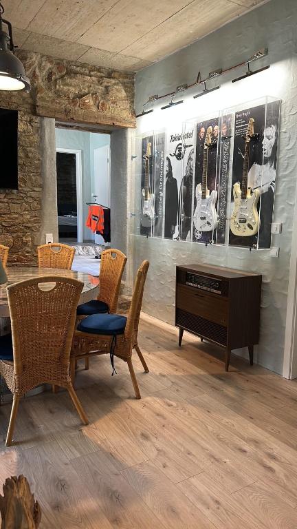 a living room with a table and chairs and a piano at Backstage, stylische Unterkunft mit Whirlpool in Dahlem