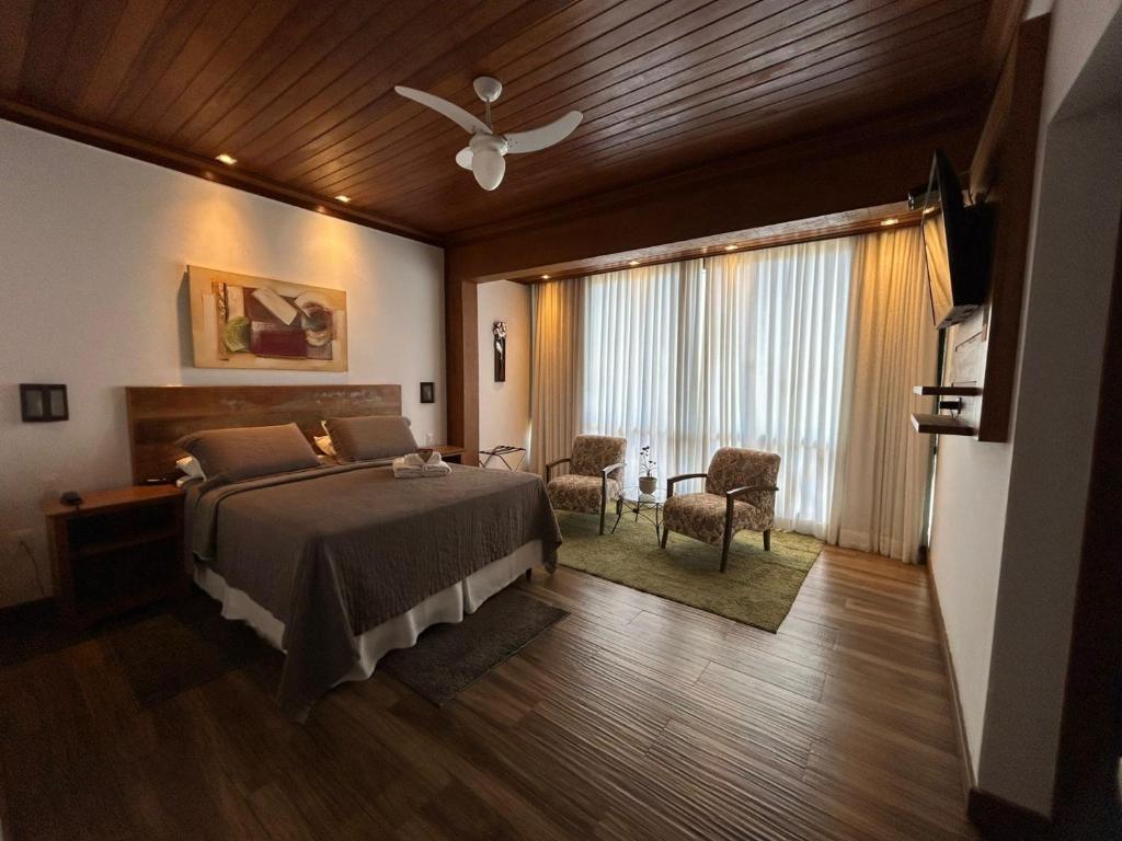 a bedroom with a bed and a ceiling fan at Pousada Carumbé Lavras Novas in Lavras Novas