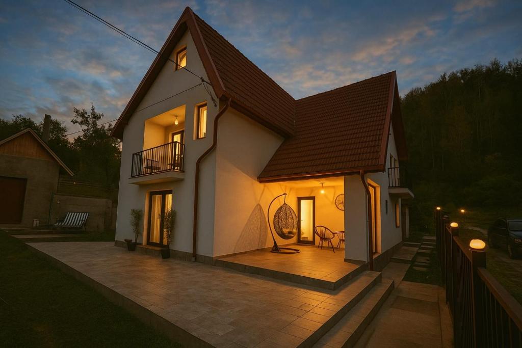 a large white house with a balcony and a patio at Pensiunea Sufletul Pădurii in Valea Lupului