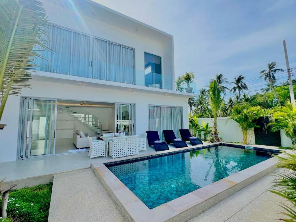 a villa with a swimming pool in front of a house at Jungle View 3 bedroom Pool Villa in Meanam in Koh Samui 