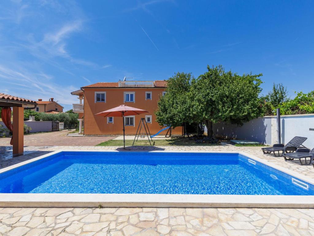 a pool with a swing and a house at Holiday Home VIlla Eldina by Interhome in Škatari