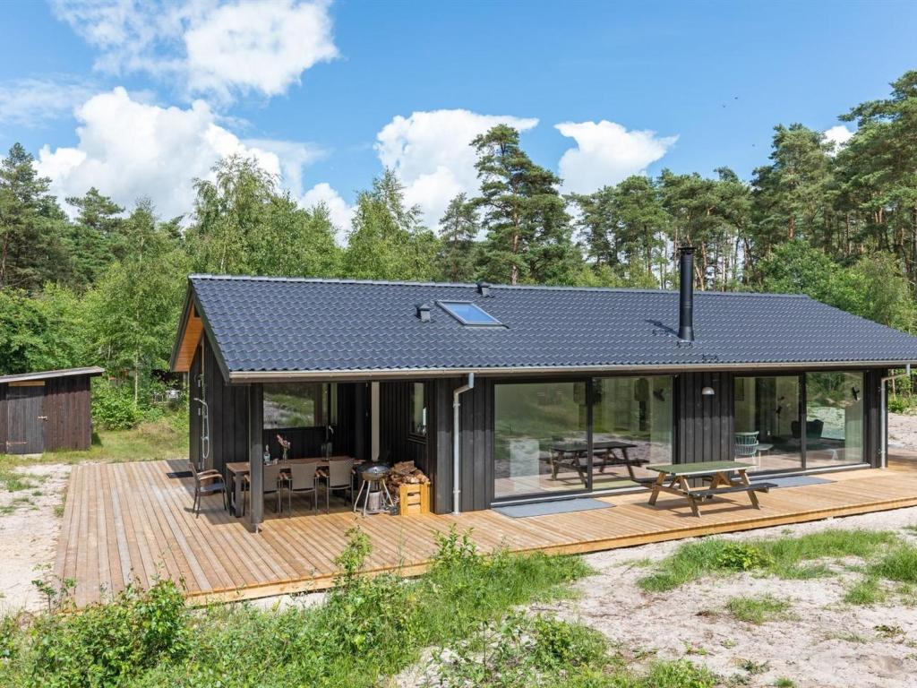 une maison avec un toit solaire sur une terrasse en bois dans l'établissement Holiday Home Anarosa - 200m from the sea by Interhome, à Vester Sømarken