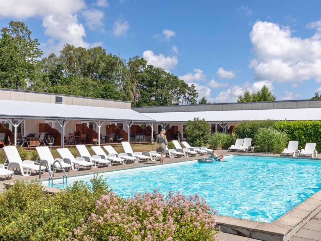 a swimming pool with lounge chairs and a building at Apartment Melita - 300m from the sea by Interhome in Neksø