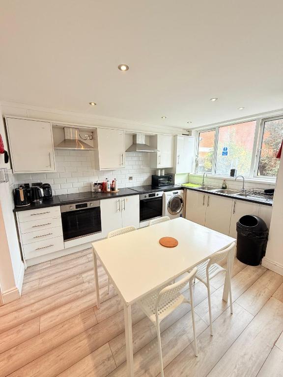ロンドンにある15 min to Central London Guest Suites 22のキッチン(白いテーブル、白いカウンタートップ付)