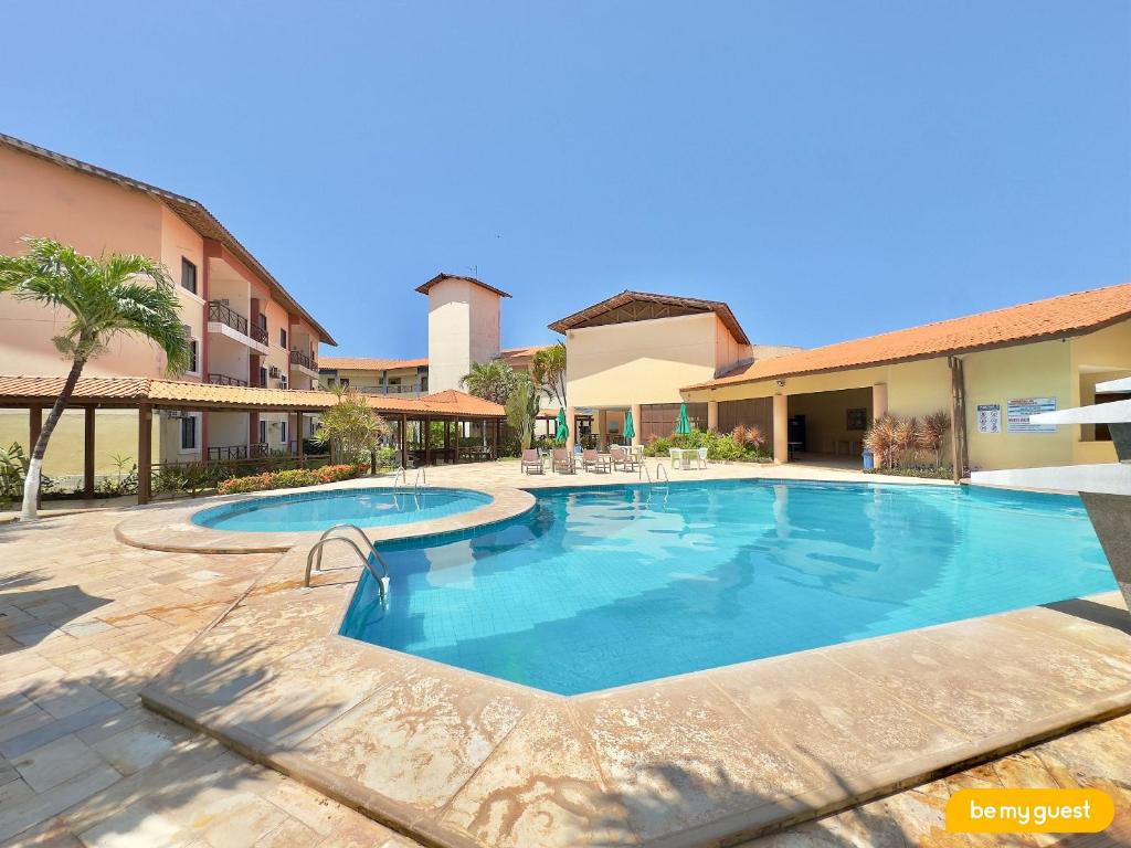 a large swimming pool in a courtyard with a building at Vila do Mar - Porto das Dunas in Aquiraz