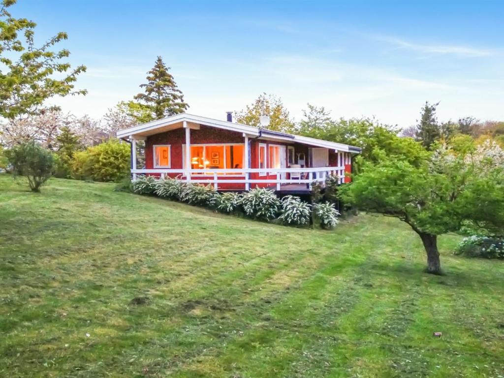 ein Haus auf einer Wiese mit einem Baum in der Unterkunft Holiday Home Hannele - 200m from the sea by Interhome in Svaneke