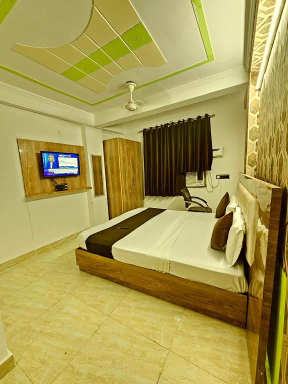 a bedroom with a bed and a television in it at Hotel Golden Tower At Delhi Airport in New Delhi