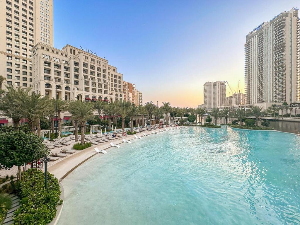 a large swimming pool in a city with buildings at FIRST CLAS 1BR Creek Beach , Lagoon Access in Dubai