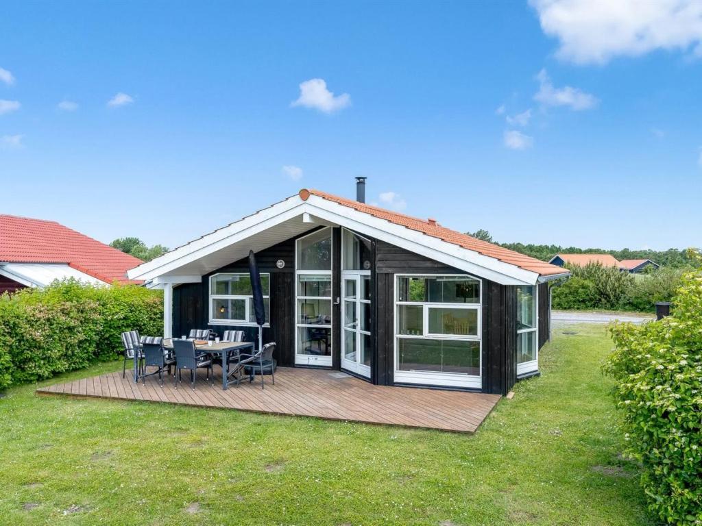 une maison en noir et blanc avec une terrasse avec une table dans l'établissement Holiday Home Birtir - 1-2km from the sea by Interhome, à Bøtø By