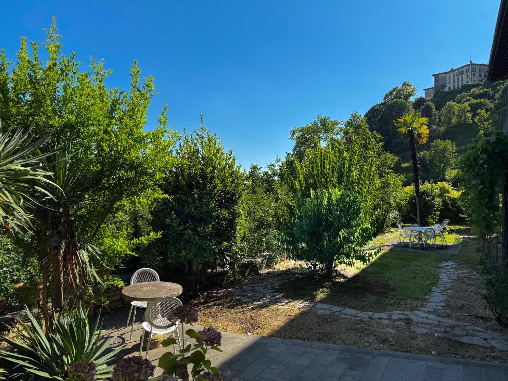 a garden with a table and chairs and trees at Fermiamoci qui in Bergamo